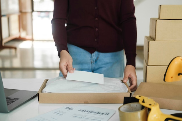 Female online business owner packing package