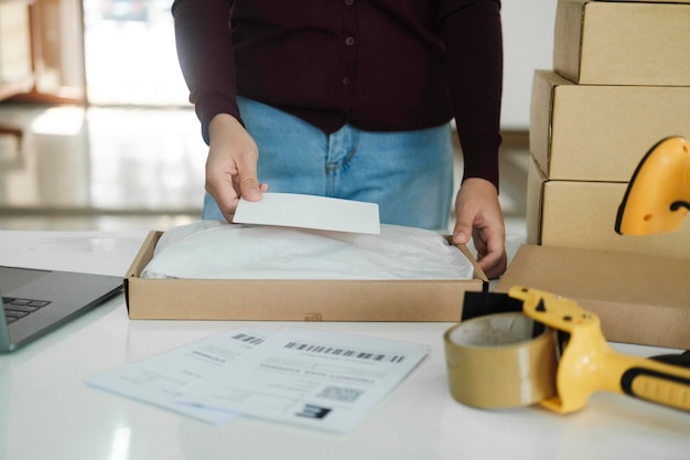 Female online business owner packing package