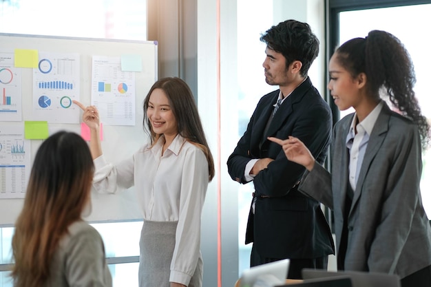 Female Operations Manager Holds Meeting Presentation for a Team of Economists Asian Woman Uses Digital Whiteboard with Growth Analysis Charts Statistics and Data People Work in Business Office