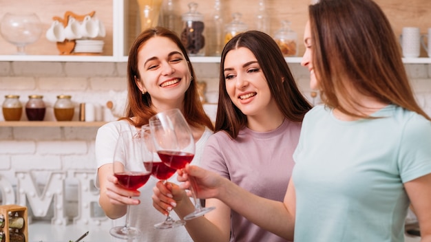 Photo female party fun. friendship celebration. happy young women clinking red wine glasses.