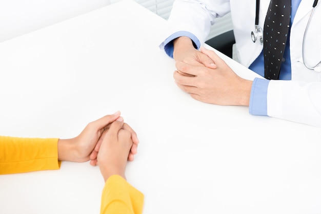 Female patient consulting with doctor at the table in the office