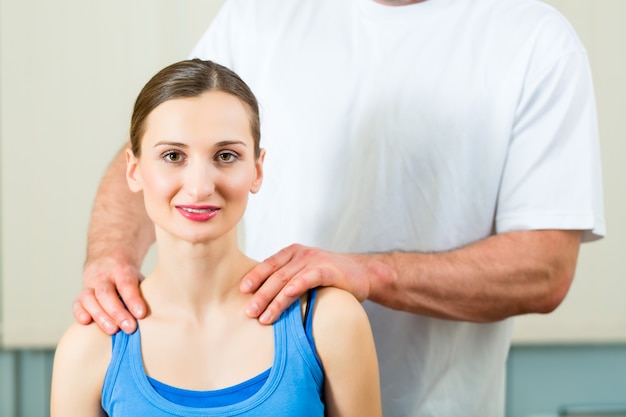 Female Patient at the physiotherapy doing physical exercises with her therapist, he gives her a medical massage