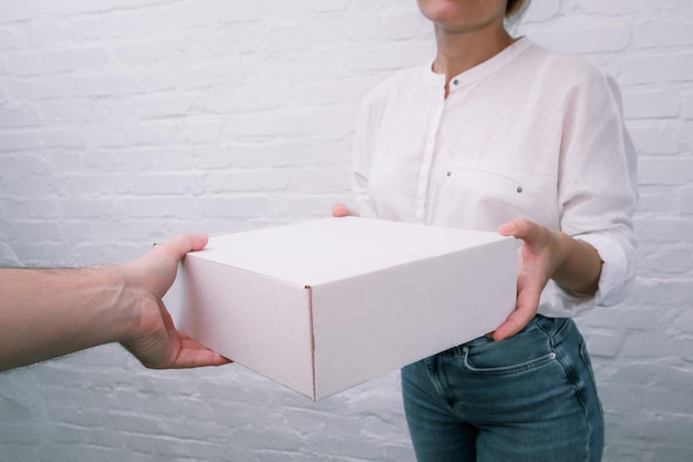 Female person receiving shipment from male courier Woman receiving parcel from courier at home