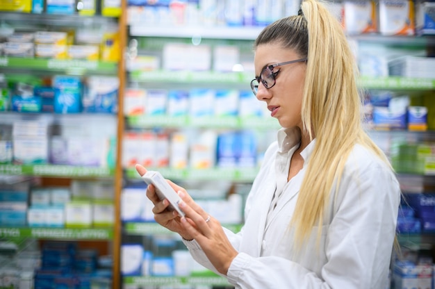 Female pharmacist analyzing a product in her store