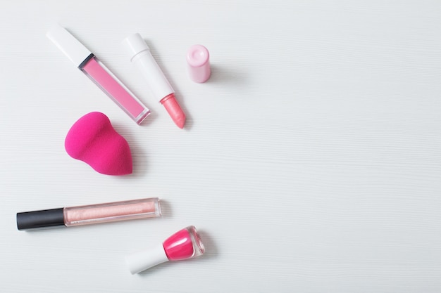 Female pink cosmetics on white background