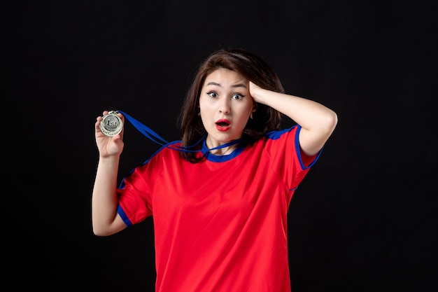 Female player with gold medal on black