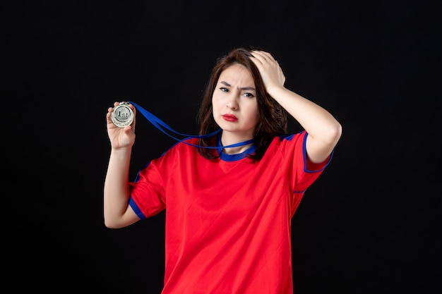 Female player with gold medal on black