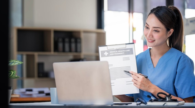 Female positive doctor having online consultation with patient on laptop in clinic office