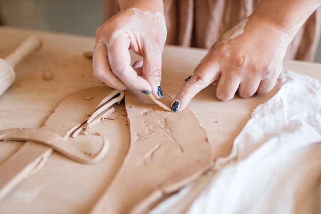 Female potter shaping clay, pottery workshop.