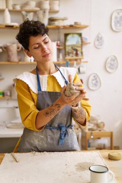 Female pottery workshop owner enjoy working with raw clay artist woman prepare potter for molding