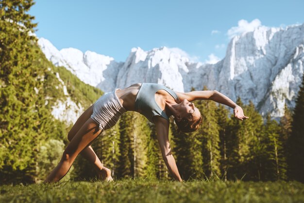 Photo female practicing yoga on nature young woman doing yoga in mountains