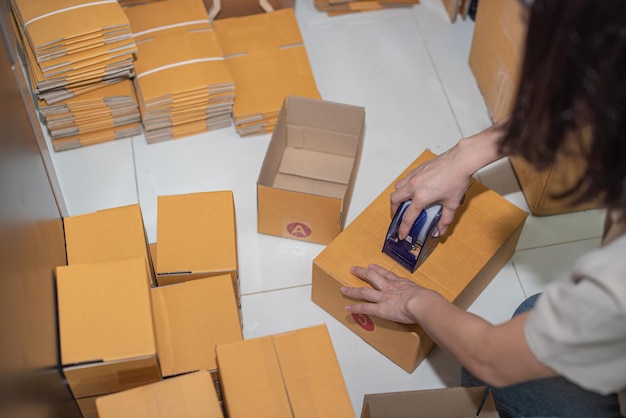 female preparing a parcel for delivery at online selling business office ecommerce drop shipping