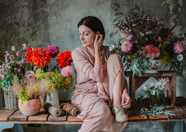 Female professional florist prepares the arrangement of wild flowers.