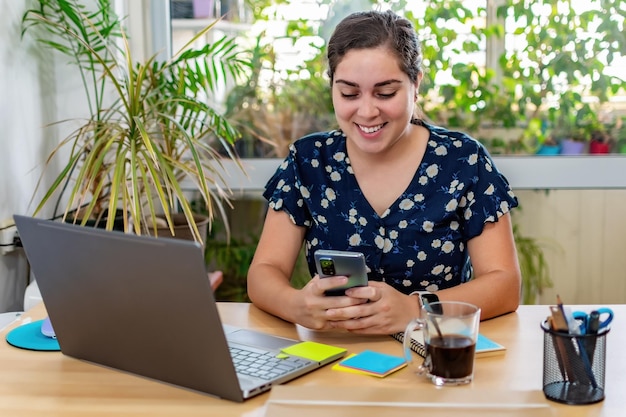 Female professional messaging online on cellphone while working at the office