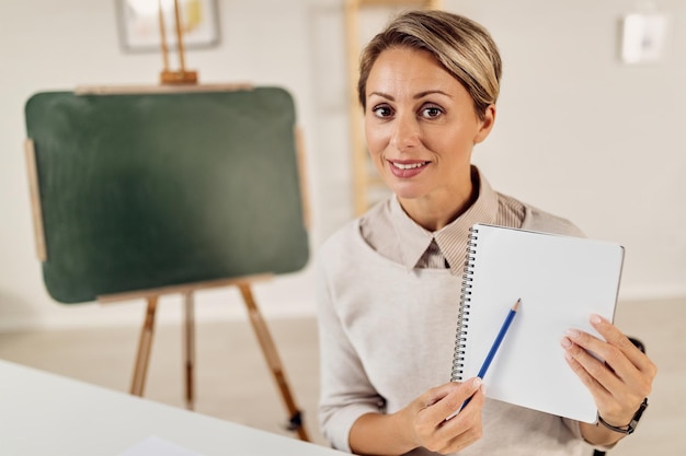 Female professor teacher students online and pointing at notebook