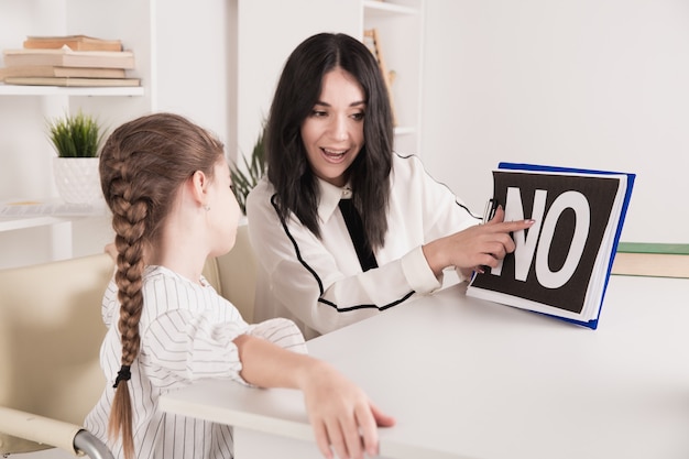 Female psychologist working with girl in the white cabinet.