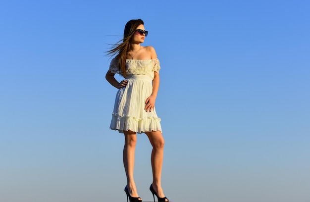 Female psychology Beautiful woman on sunny day blue sky Fancy model in tender summer dress Freedom and Harmony Summer fashion Girl in sunglasses copy space Towards summer Wind of change