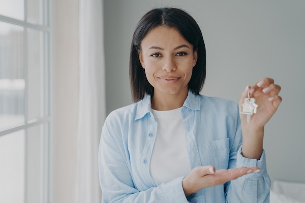 Female real estate agent showing keys to new home offering apartment Sale of housing mortgage