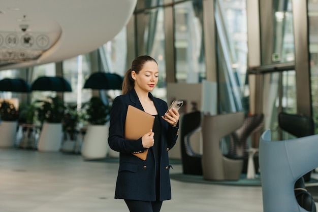 A female realtor in a blazer is working at the table in the modern lobby