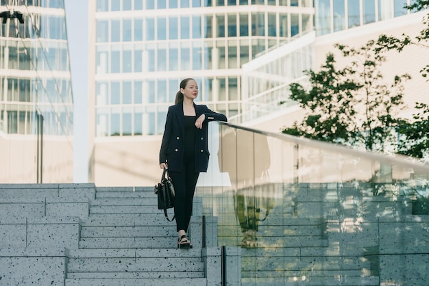 A female realtor is leaning on the glass parapet on the stairs