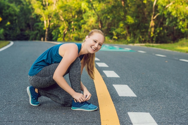 Female runner tying her shoes preparing for jogging outside .Young girld runner getting ready for training. Sport lifestyle