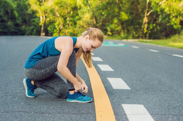 Female runner tying her shoes preparing for jogging outside .Young girld runner getting ready for training. Sport lifestyle