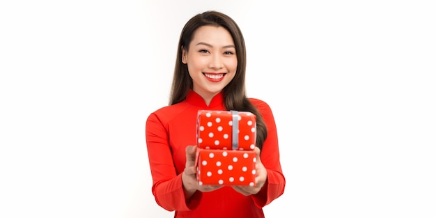 Female's hands in red ao dai holding gift box on white background Christmas New Year Valentine's day and birthday concept