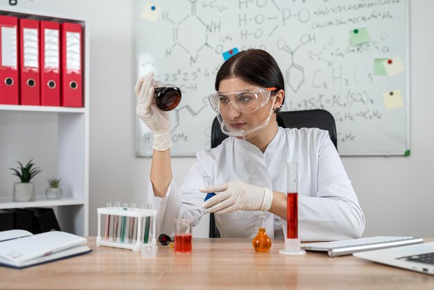 Female scientific laboratory looking on test tube with reagent for experiment