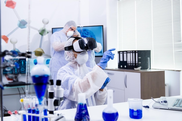 Female scientist doing experimental test using virtual reality goggles in modern research laboratory.