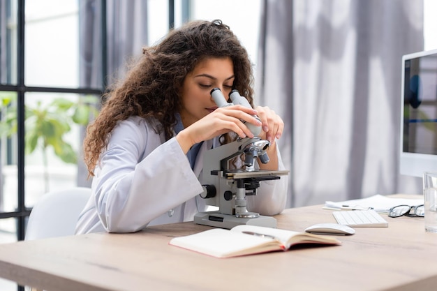 Female scientist in medicine coat works in a scientific laboratory