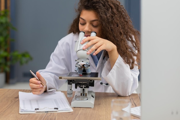 Female scientist in medicine coat works in a scientific laboratory