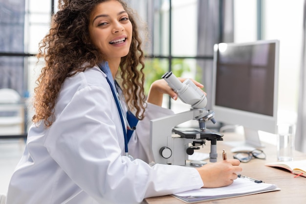 Female scientist in medicine coat works in a scientific laboratory