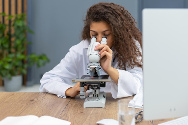 Female scientist in medicine coat works in a scientific laboratory