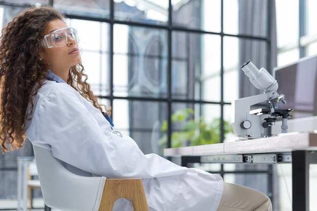 Female scientist in medicine coat works in a scientific laboratory