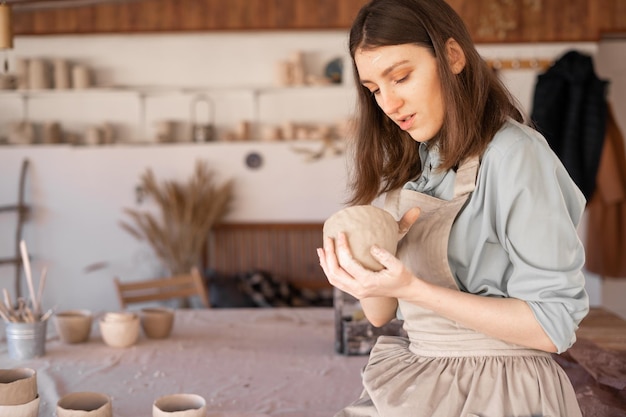 Photo a female sculptor models a clay pottery bowl