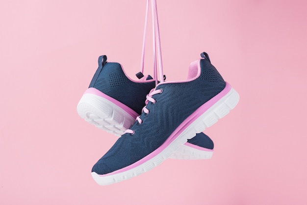 Female sneakers for run on a pink background. Fashion stylish sport shoes, close up