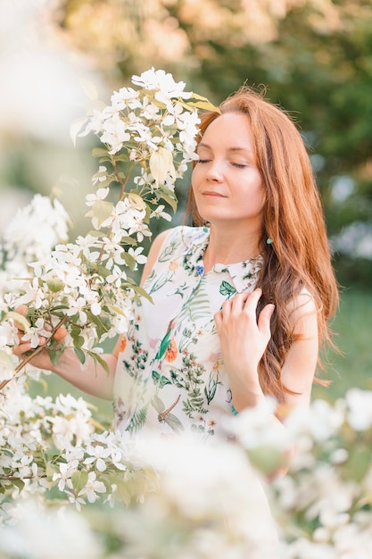 Female street portrait in blossoming of apple-trees. High quality photo