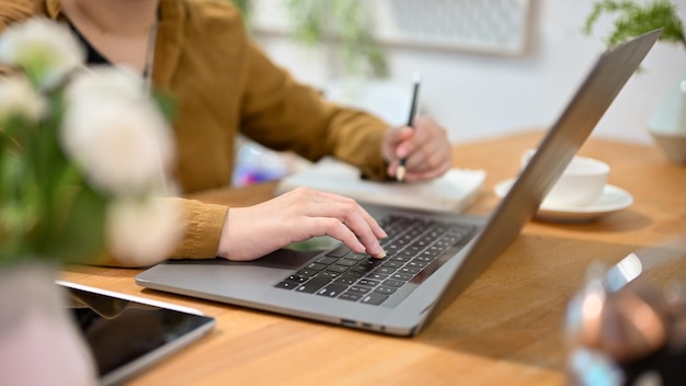 Female student doing homework and searching the information on the internet via laptop