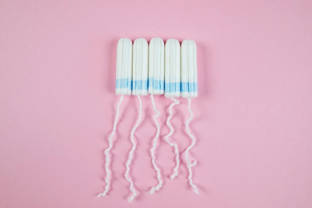 Female tampons on a pink background Hygienic white tampon for women Cotton swab Menstruation