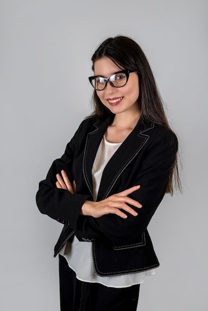 Female teacher in modest clothes with folded hands on her chest isolated on a plain background