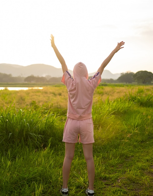 Female teen girl stand feel freedom and relaxation travel outdoor enjoying nature with sunrise.