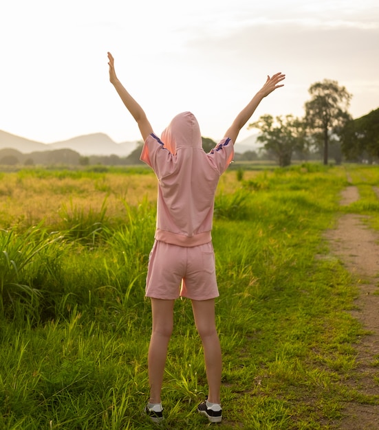 Female teen girl stand feel freedom and relaxation travel outdoor enjoying nature with sunrise.