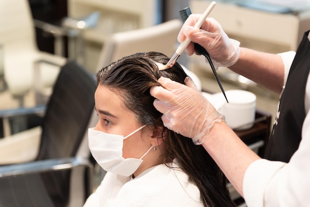 A female teenager patient getting a hair treatment with a brush