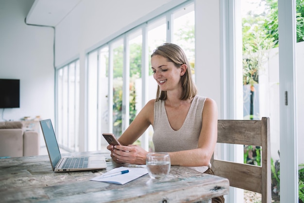 Female teleworker on break using smartphone