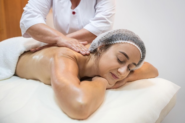 female therapist rubs a lady's back giving her a relaxing massage