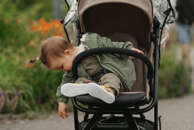 A female toddler is sitting in the stroller on a cloudy day