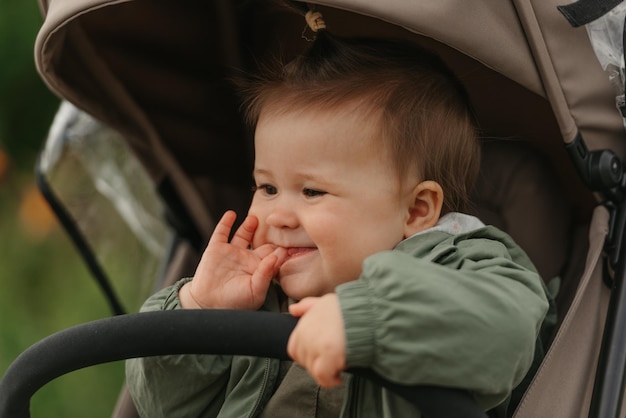 A female toddler is sitting in the stroller on a cloudy day