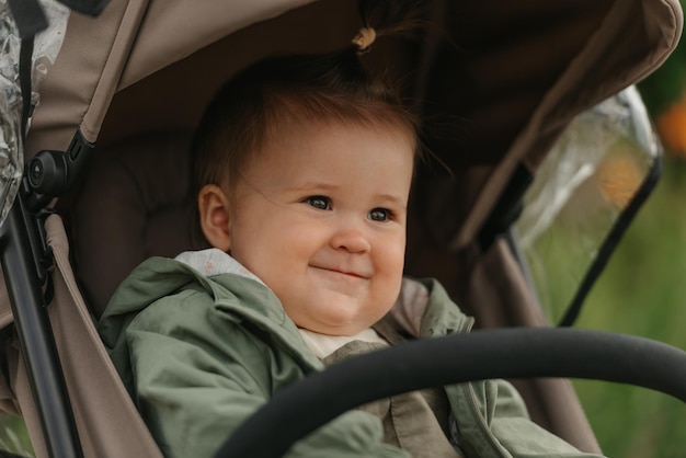 A female toddler is sitting in the stroller on a cloudy day