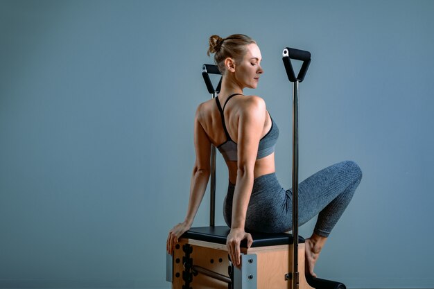 Female trainer posing for a reformer in the gym