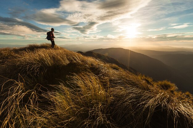 Female tramper standing on mountain in warm evening light Southern Crossing Tararua Forest Park New Zealand